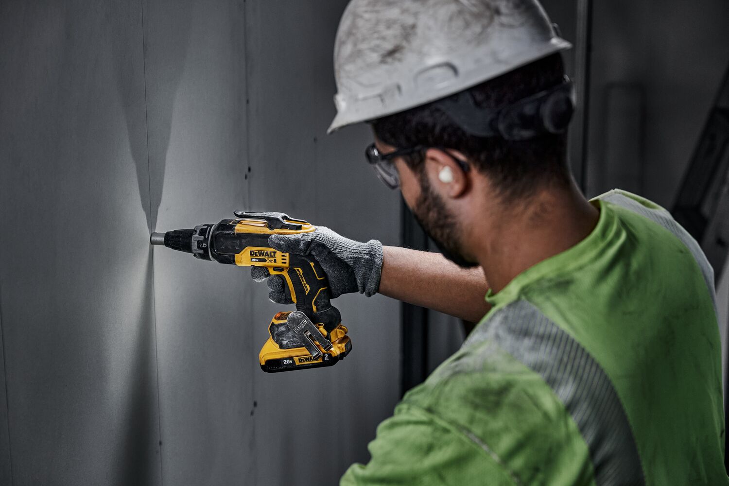 individual using a 20V MAX XR(®) Brushless Drywall Screwgun on a wall
