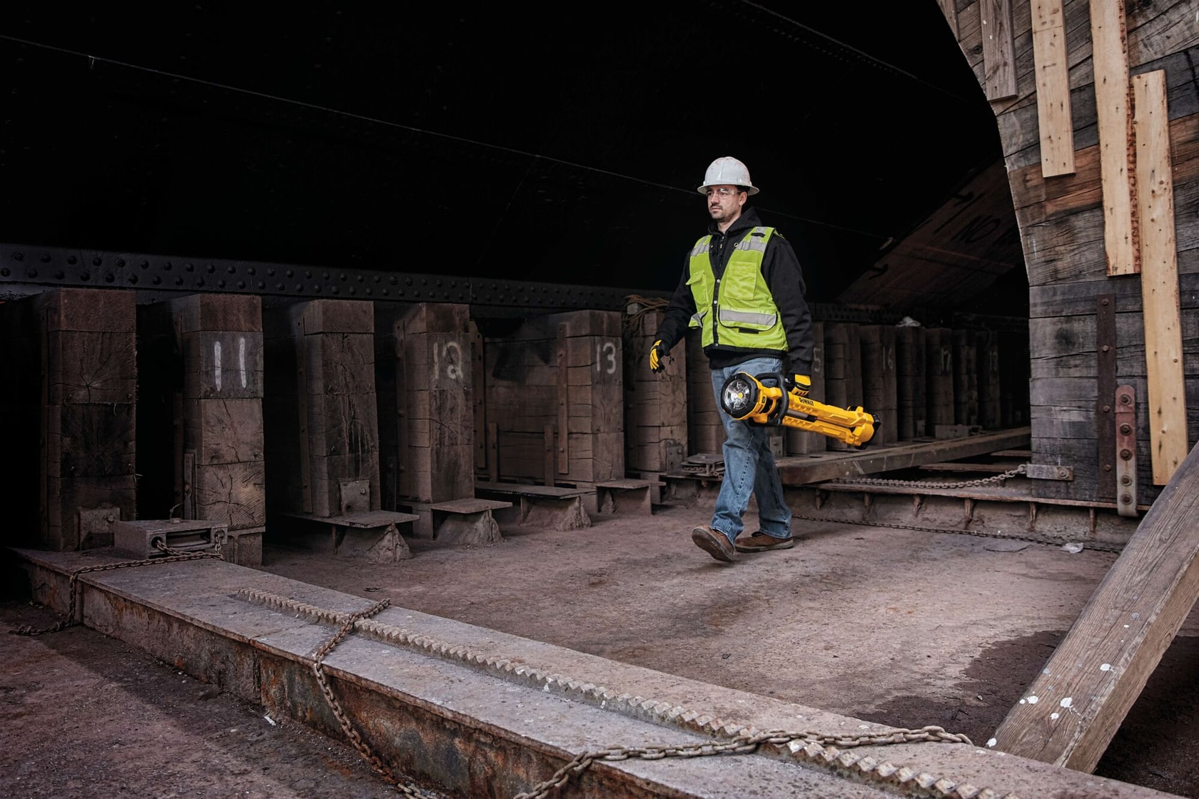 cordless tripod light being adjusted by a person at a construction site