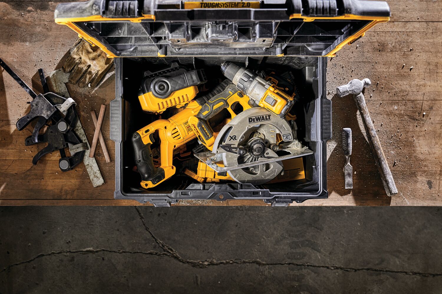 Overhead view of tough system 2.0 large toolbox with tools placed inside it on a table next to a hammer.
