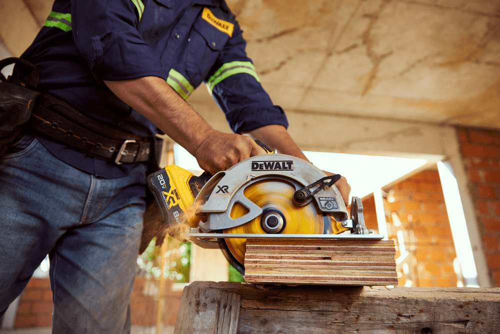 Worker using Circular saw DCS570 cutting wood